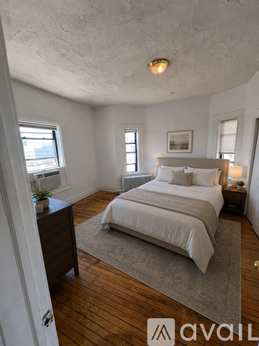 A bedroom with a large bed and wooden floors.