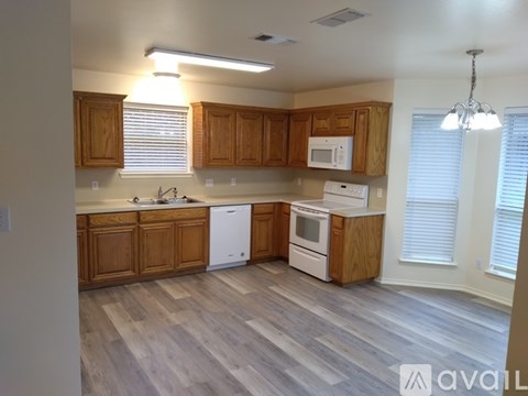 A kitchen with wooden cabinets and a white dishwasher.