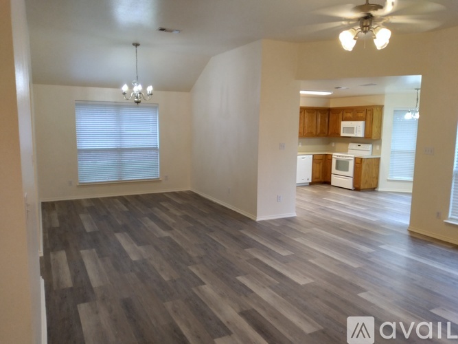 A spacious room with wooden flooring and a ceiling fan.