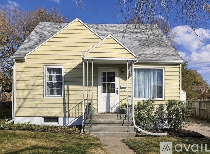 A two-story house with a front porch and a white door.