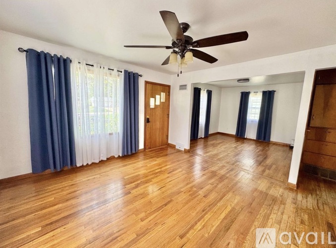 A room with wooden floors and a ceiling fan.