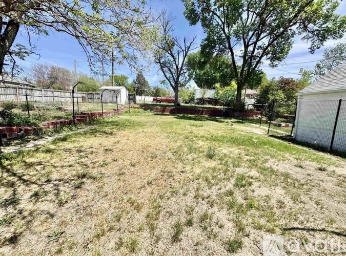 A backyard with a fence and trees.