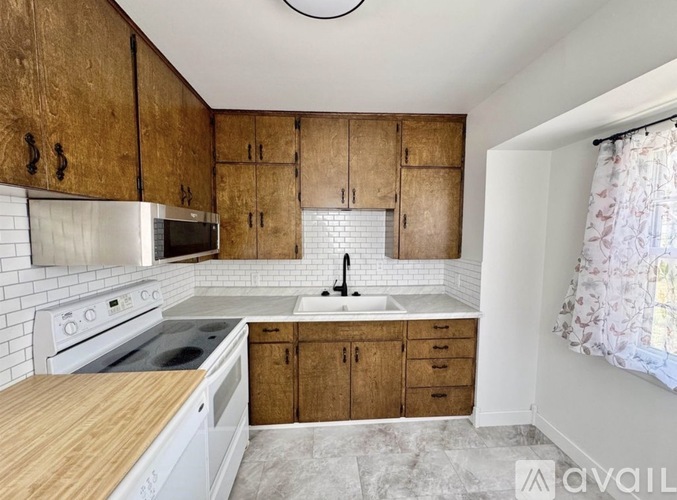 A kitchen with wooden cabinets and white appliances.