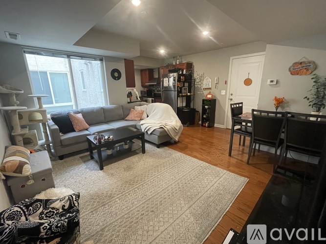 A living room with a grey sofa and a grey rug.