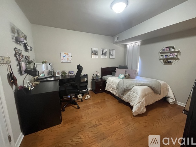 A bedroom with a bed, desk, and chair.