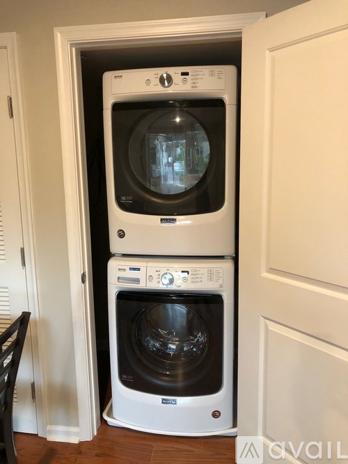 A white washing machine and dryer stacked on top of each other in a small space.