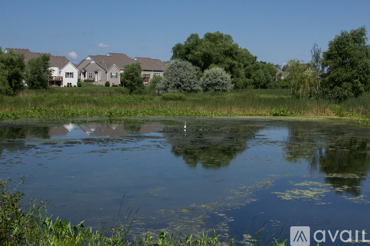 A body of water with reflections of the sky and trees.