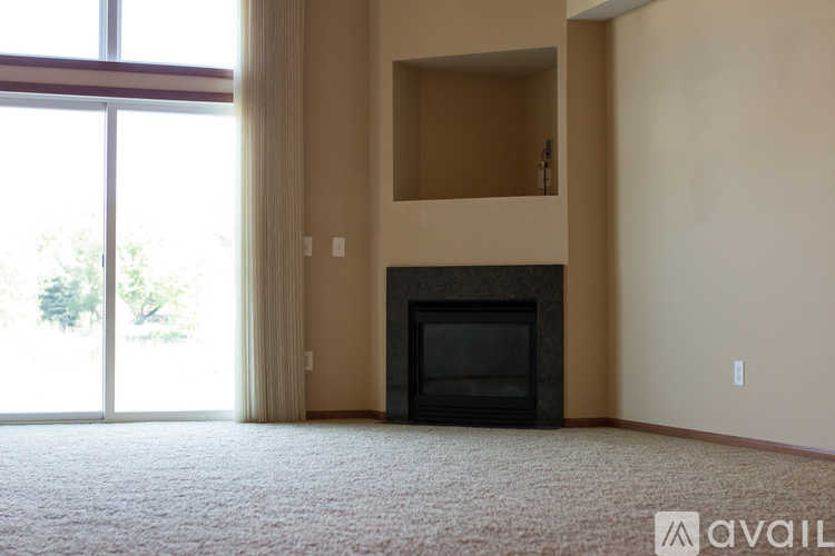 A living room with a fireplace and a carpet.