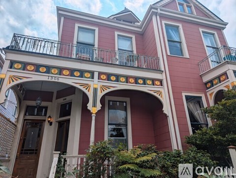 A red building with a balcony and a sign that says "avon".
