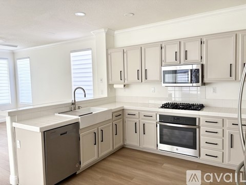 A kitchen with white cabinets and a stainless steel oven.