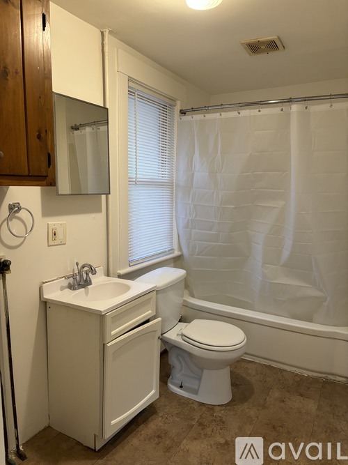 A bathroom with a toilet, sink, and bathtub.