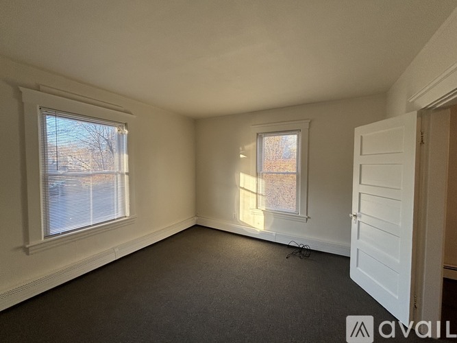 A room with a window and a door is available for rent.