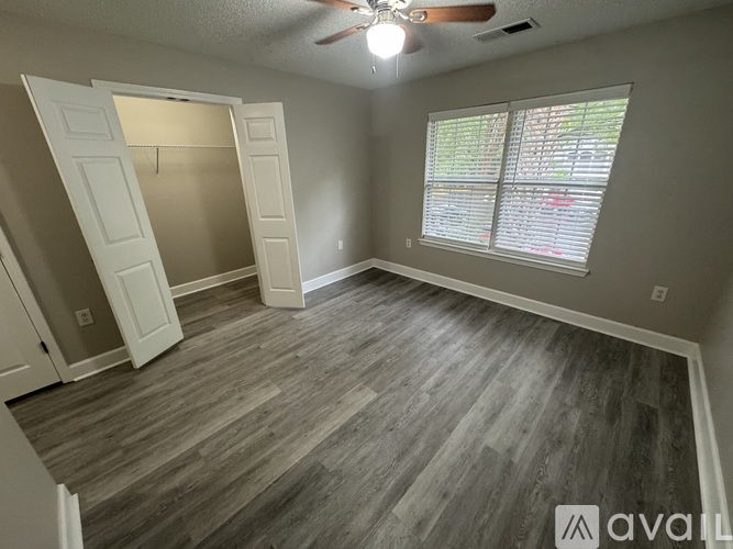 A room with a ceiling fan and a doorway leading to another room.