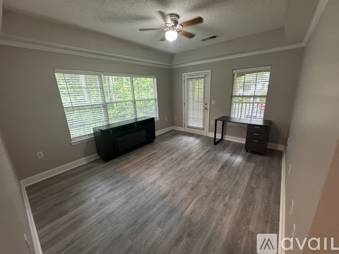 A room with a ceiling fan and a window with blinds.