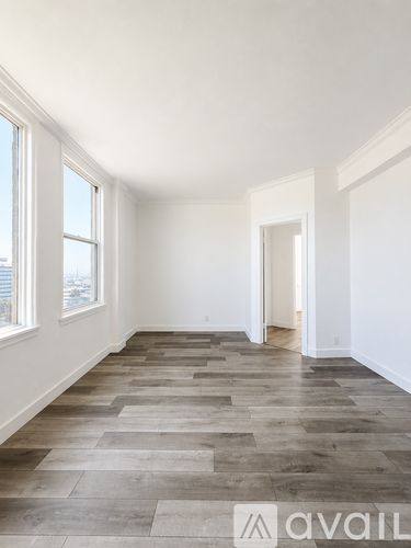 A room with wooden flooring and white walls.