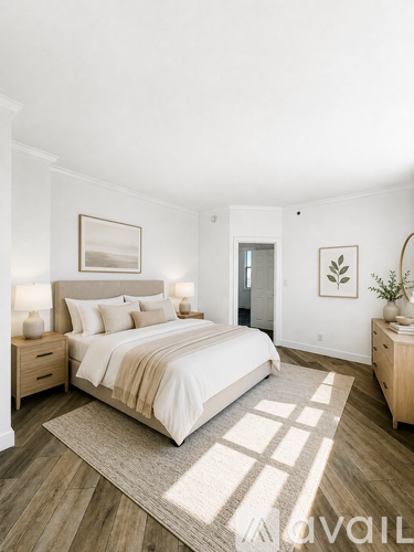 A bedroom with a large bed, two nightstands, and a rug on the floor.