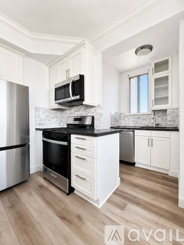 A kitchen with a stainless steel refrigerator and a black stove top oven.
