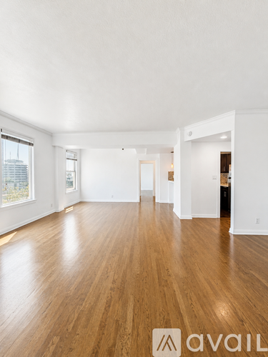 A spacious room with wooden floors and white walls.