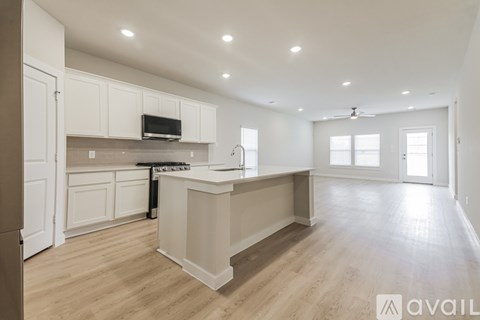 A kitchen with white cabinets and a wooden island.