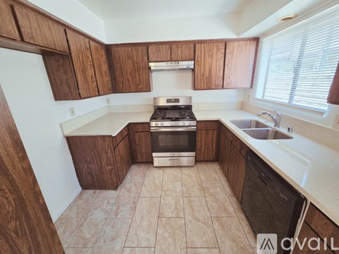 A kitchen with wooden cabinets and a white stove top oven.