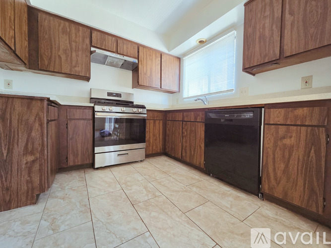 A kitchen with wooden cabinets and a stainless steel oven.