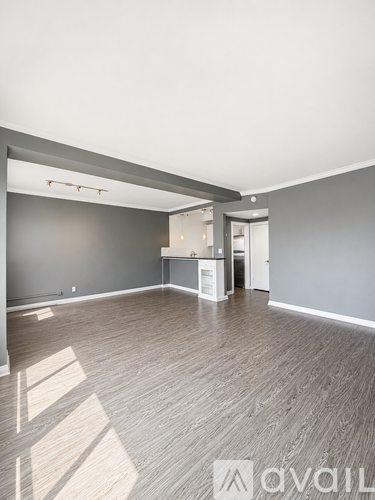A spacious room with wooden flooring and a white ceiling.