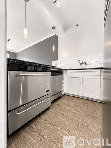 A modern kitchen with a stainless steel oven and white cabinets.
