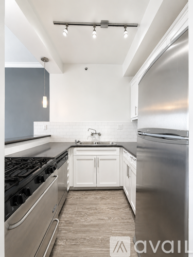 A modern kitchen with stainless steel appliances and white cabinetry.