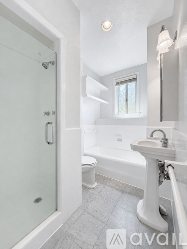 A bathroom with a white sink and a glass shower door.