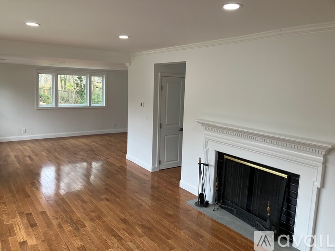 A living room with a fireplace and hardwood floors.