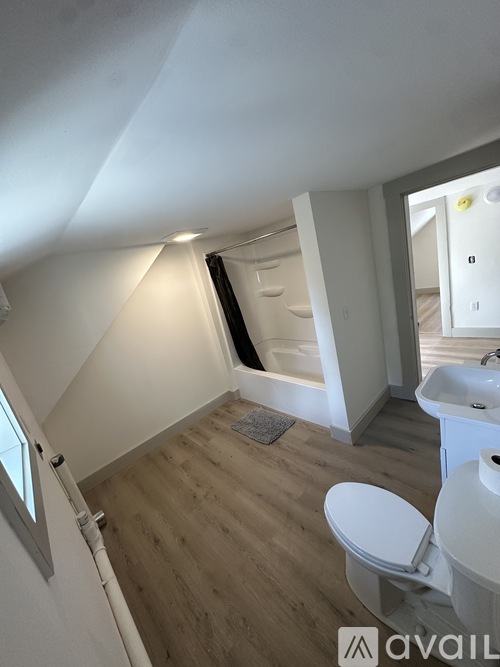 A bathroom with a toilet, sink, and mirror.