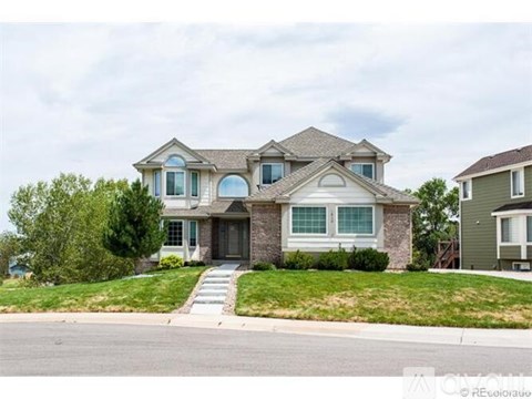A large, two-story house with a front porch and a garage.