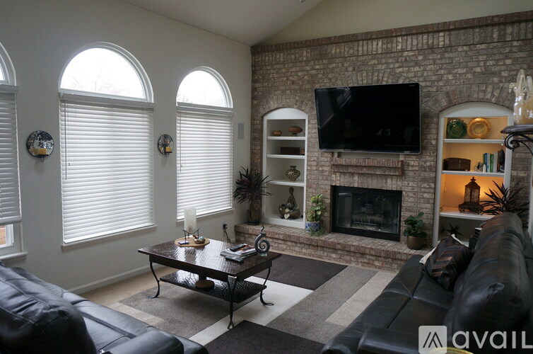 A living room with a fireplace and a TV mounted on the wall.