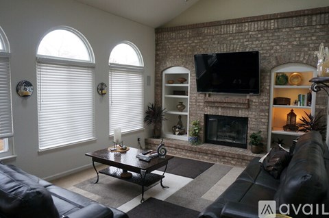 A living room with a fireplace and a TV mounted on the wall.