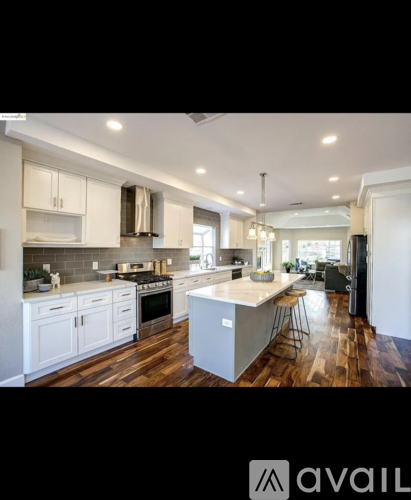 A modern kitchen with white cabinets and a central island.