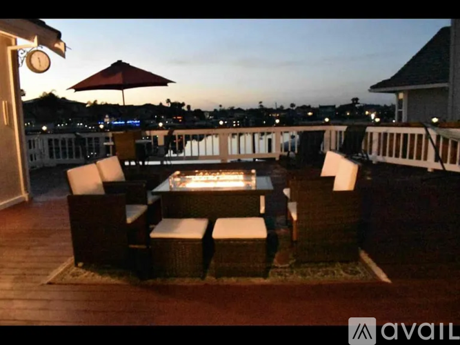 A patio with a table and chairs overlooking a cityscape at dusk.