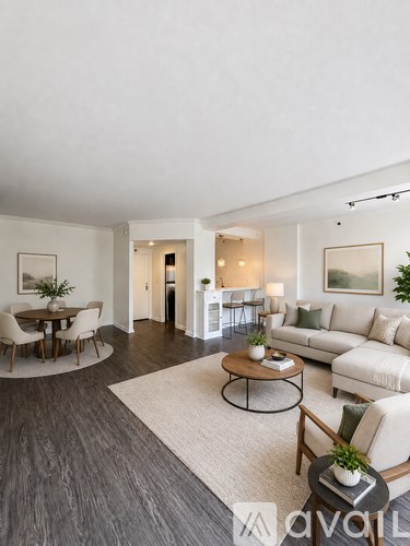 A living room with a white couch, a coffee table, and a dining table with chairs.