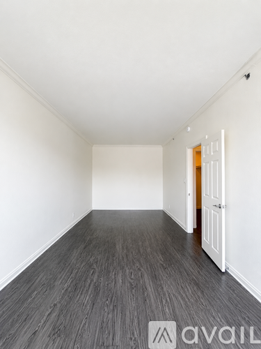 A room with wooden flooring and white walls.