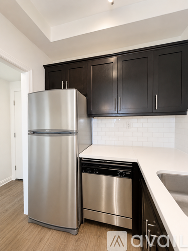 A modern kitchen with a stainless steel refrigerator and dishwasher.