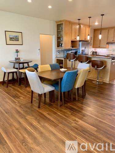 A dining room with a table surrounded by chairs.
