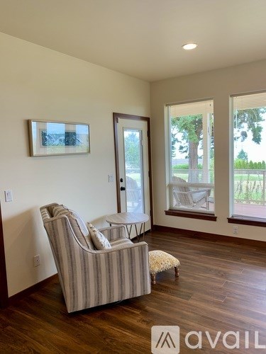 A living room with a striped chair and a picture on the wall.