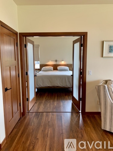 A bedroom with a bed and a chair in it.