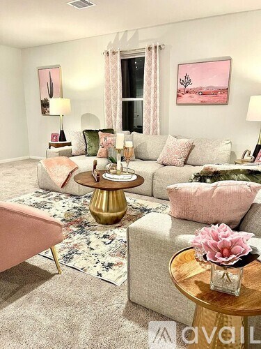 A living room with a pink couch and a gold coffee table.