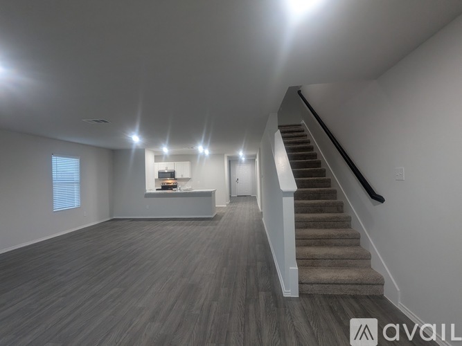 A spacious room with a staircase leading to the upper floor.