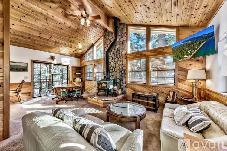 A living room with a wooden ceiling and a large window.
