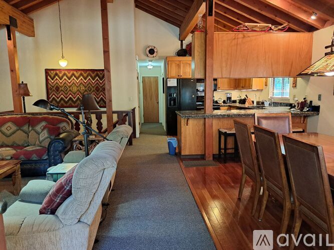 A living room with a couch and a kitchen in the background.