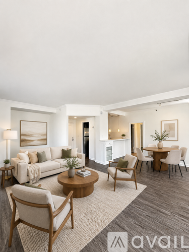 A living room with a white couch, a coffee table, and a dining table with chairs.