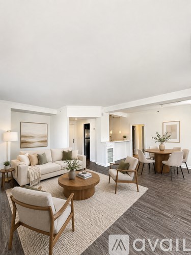 A living room with a white couch, a coffee table, and a dining table with chairs.