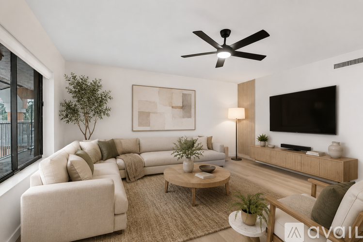A living room with a white ceiling fan and a large sectional sofa.