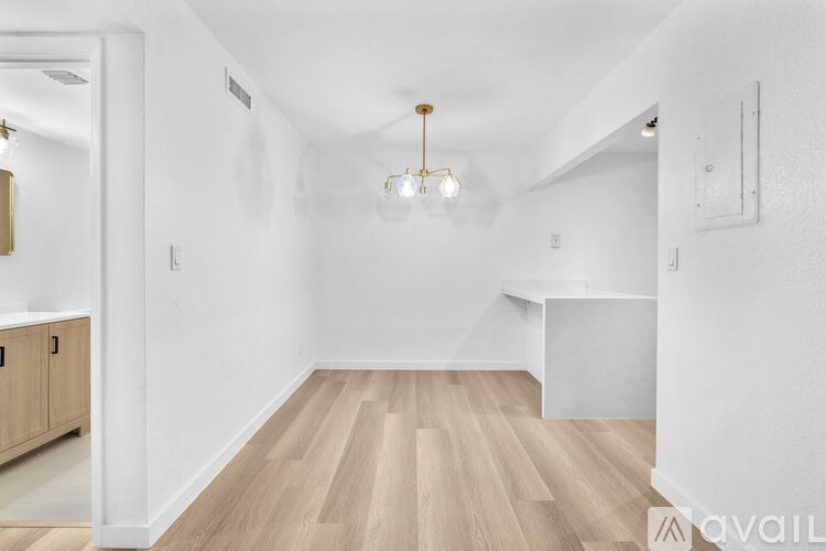 A spacious room with wooden flooring and a white ceiling.